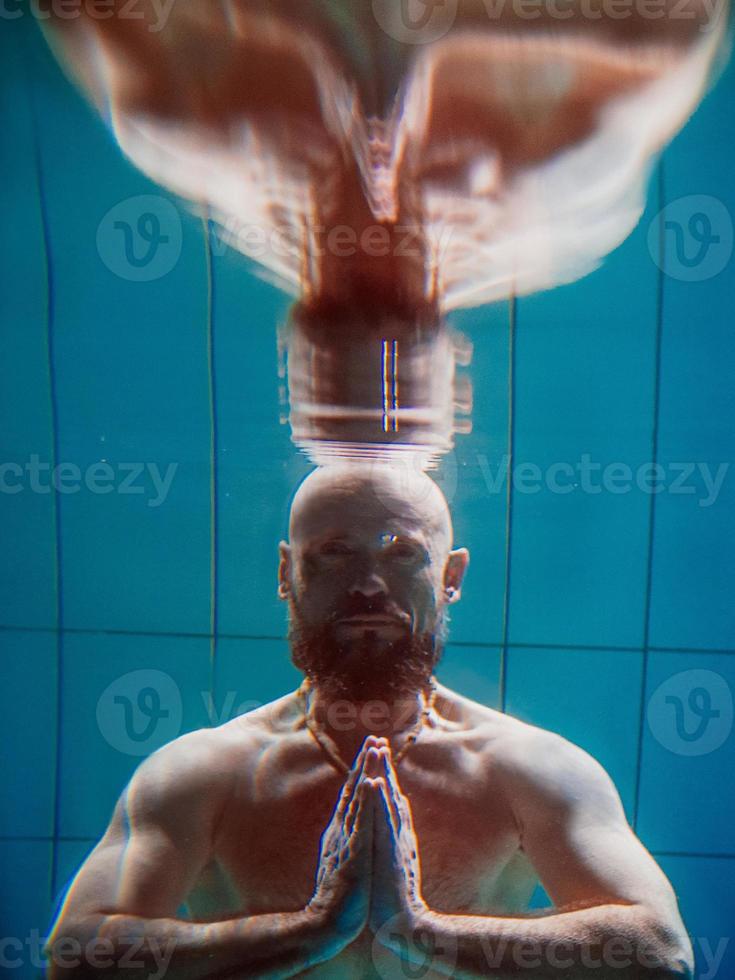 homme de sport athlétique sous l'eau dans la piscine. sports, yoga, concept de plongée libre photo