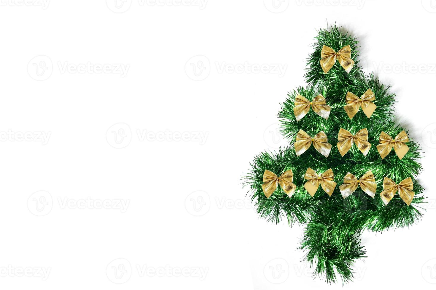 arbre de noël vert avec des arcs faits de guirlandes sur fond blanc. photo