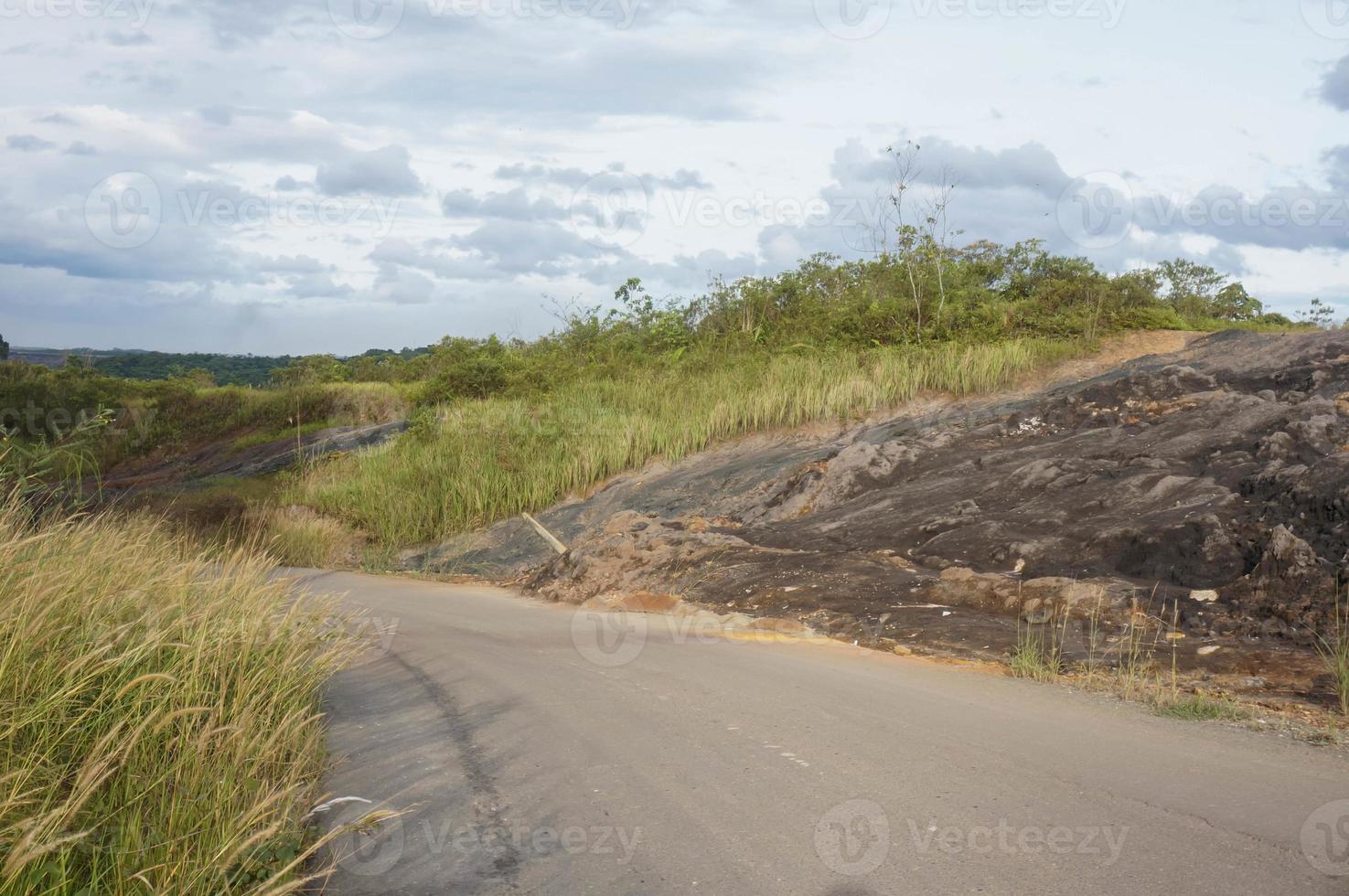 rochers bloquant la route à cause d'un glissement de terrain. glissement de terrain dans une route en béton produit par l'exploitation forestière commerciale et l'abattage d'arbres. rans route provinciale kalimantan est, indonésie. photo