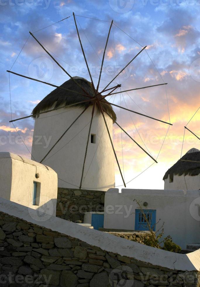 moulin à vent sur l'île grecque de mykonos avec le coucher du soleil éclairant les nuages. photo