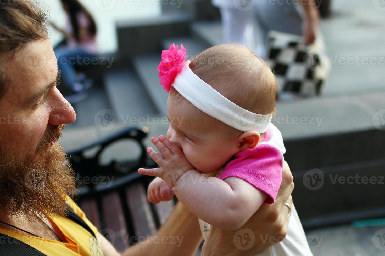 le père tient sa fille dans les mains et la regarde dans les yeux. photo