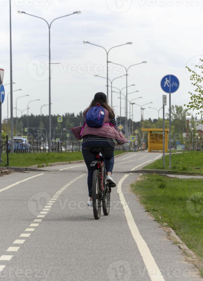 jolie jeune femme aux grosses cuisses fait du vélo dans les rues de la ville photo