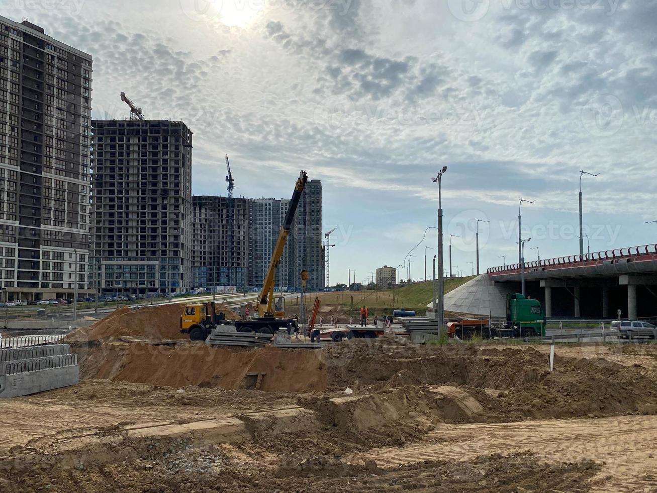 de grands bâtiments et maisons modernes et magnifiques sont des gratte-ciel en béton construits industriellement à l'aide d'une technologie de châssis monolithique à l'aide d'équipements de construction et de grues photo