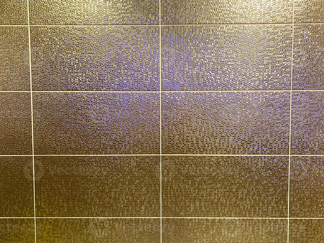 beaux carreaux de mur en céramique coûteux chic doré dans la salle de bain avec des coutures. arrière-plan, texture photo