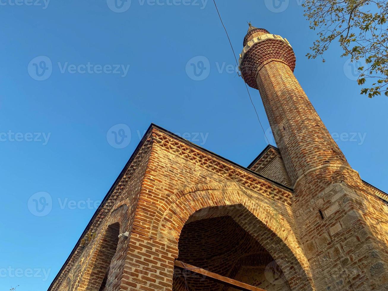 la mosquée islamique est une grande mosquée musulmane pour les prières, un ancien bâtiment en briques anciennes avec une haute tour dans une station balnéaire du sud du pays tropical chaud et touristique photo