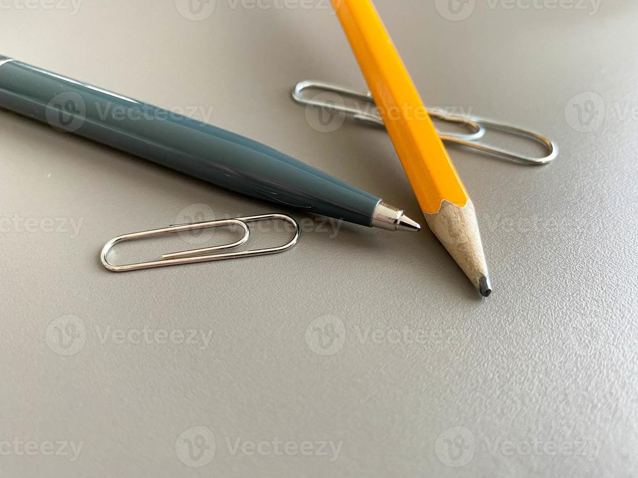 stylo à bille vert automatique et crayon avec trombones pour écrire sur votre bureau de bureau. travail d'entreprise photo