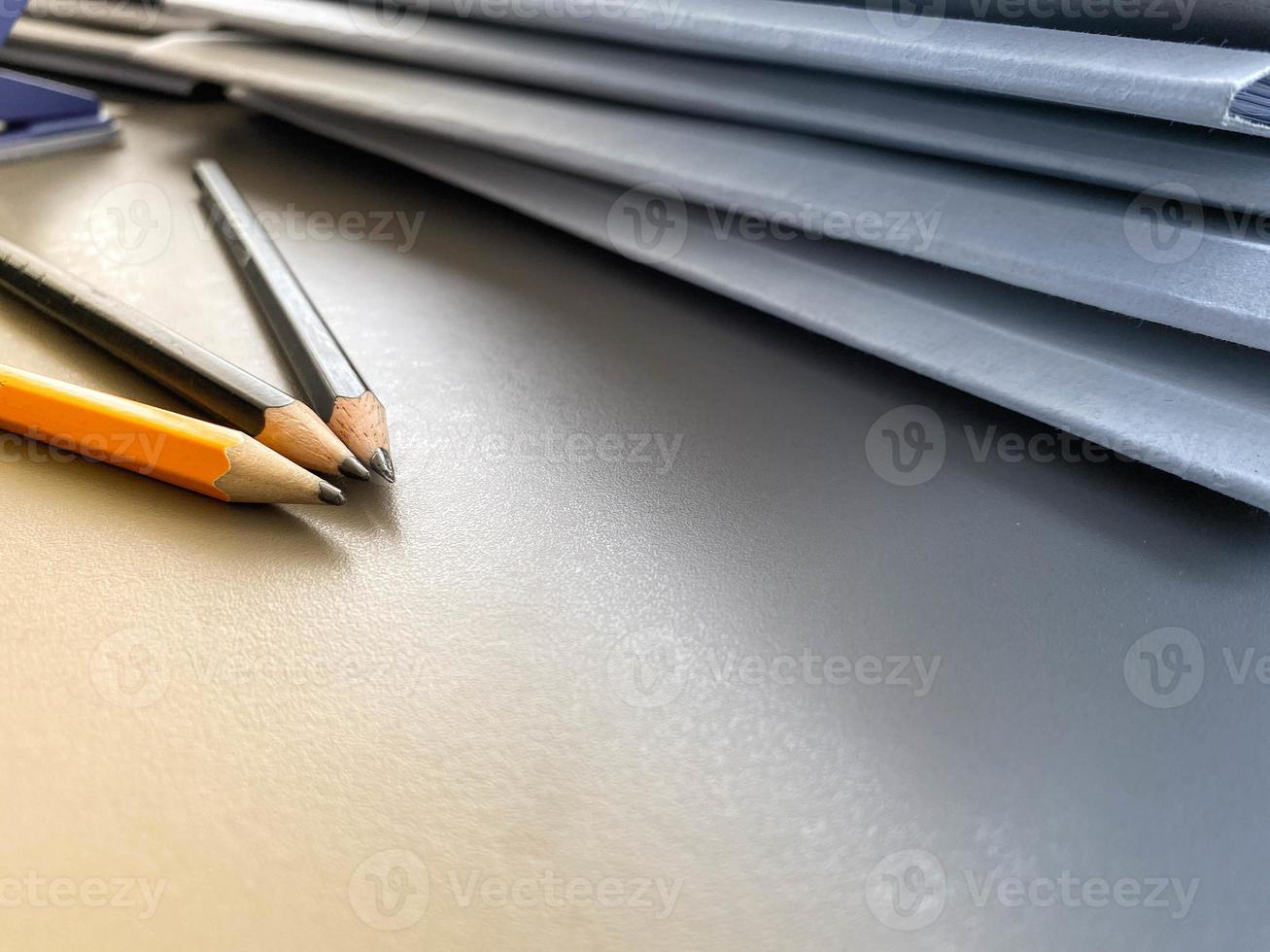 trois crayons sont aiguisés à côté de dossiers avec des feuilles de papier et des documents sur le bureau de travail du bureau. papeterie photo