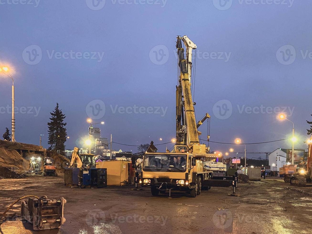 matériel de construction sur le site de réparation du viaduc. une grande grue jaune en métal soulève de lourds blocs de béton à une hauteur pour la construction d'un pont photo