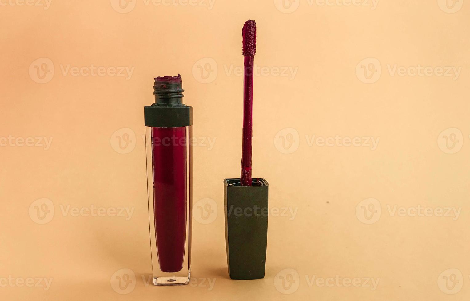tube ouvert de rouge à lèvres liquide et baguette applicatrice isolé sur fond blanc. brillant à lèvres rose vif photo