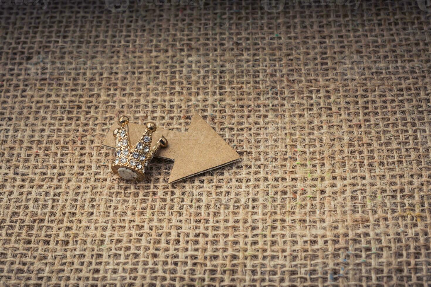mini couronne et une flèche découpées dans du papier brun photo