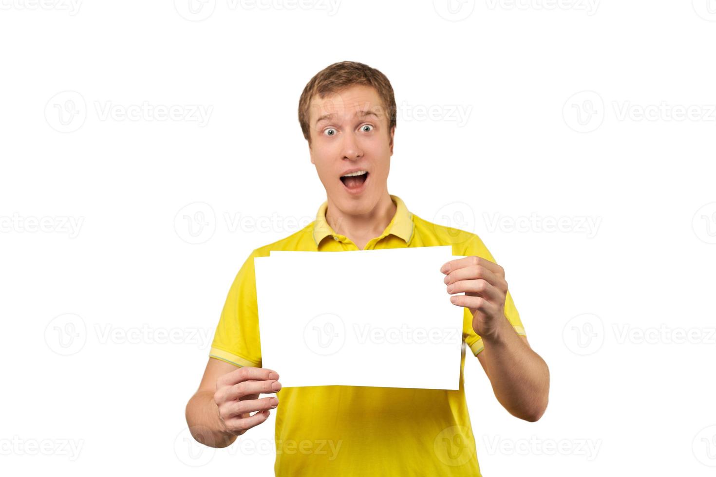 jeune homme surpris tenant une feuille de papier vierge, maquette de papier isolée sur fond blanc photo