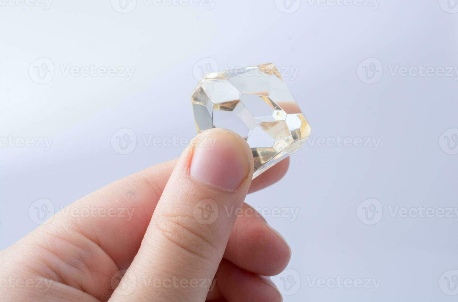 main tenant un diamant transparent sur fond blanc photo