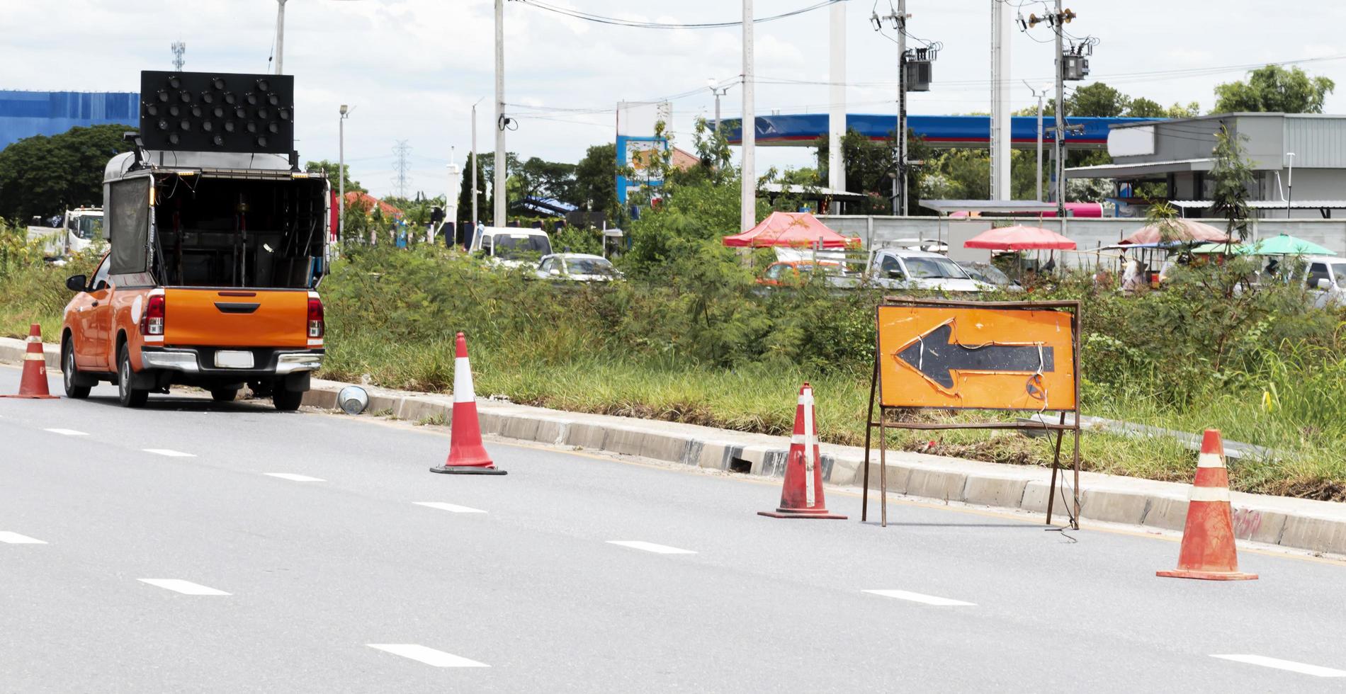 panneau de signalisation orange avec icône de flèche et cônes de signalisation sur l'autoroute photo