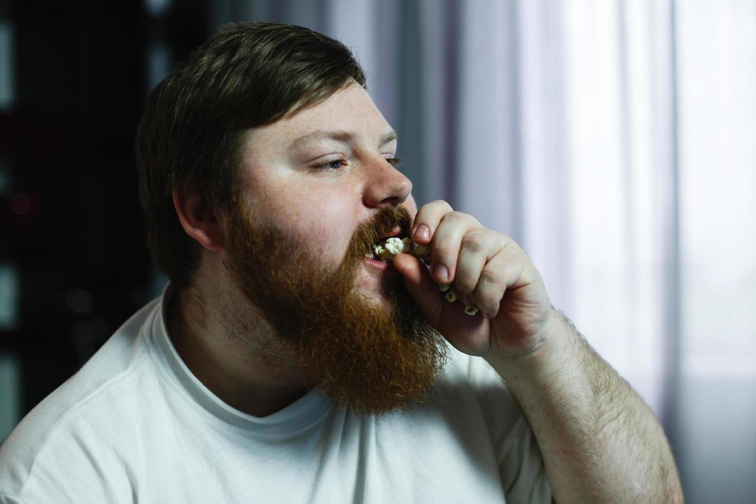 homme avec du pop-corn dans sa bouche photo