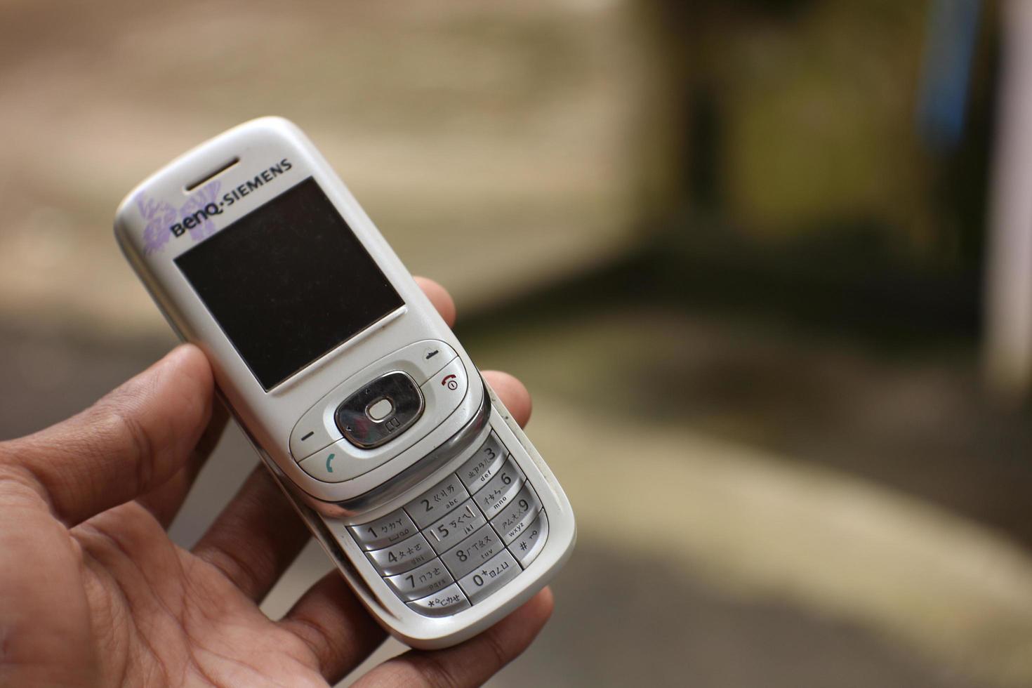 magelang, indonésie, 2022-main tenant un ancien téléphone portable blanc pas encore une version android. photo