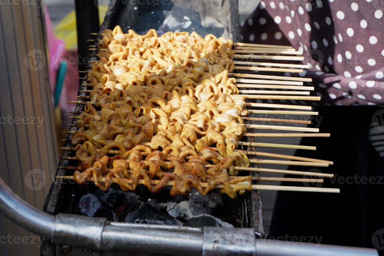 mise au point sélective sur le satay d'intestin de poulet et les boulettes de viande grillées brochées à l'aide de bambou et vendues lors de festivals culinaires. grillé au charbon de bois photo