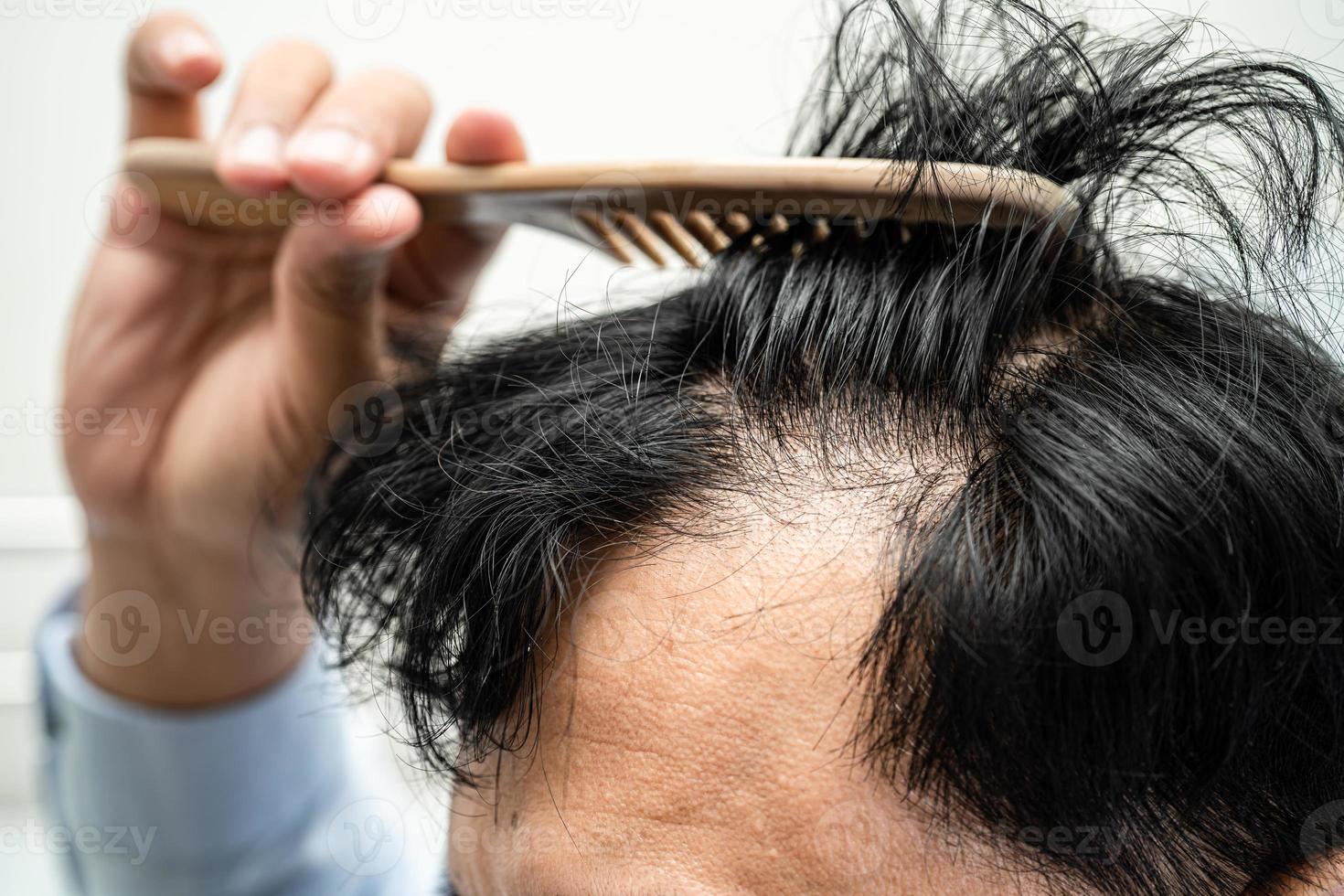 chauve au milieu de la tête et ne commence pas à perdre les cheveux glabres d'un homme de bureau actif et intelligent d'affaires asiatiques matures. photo