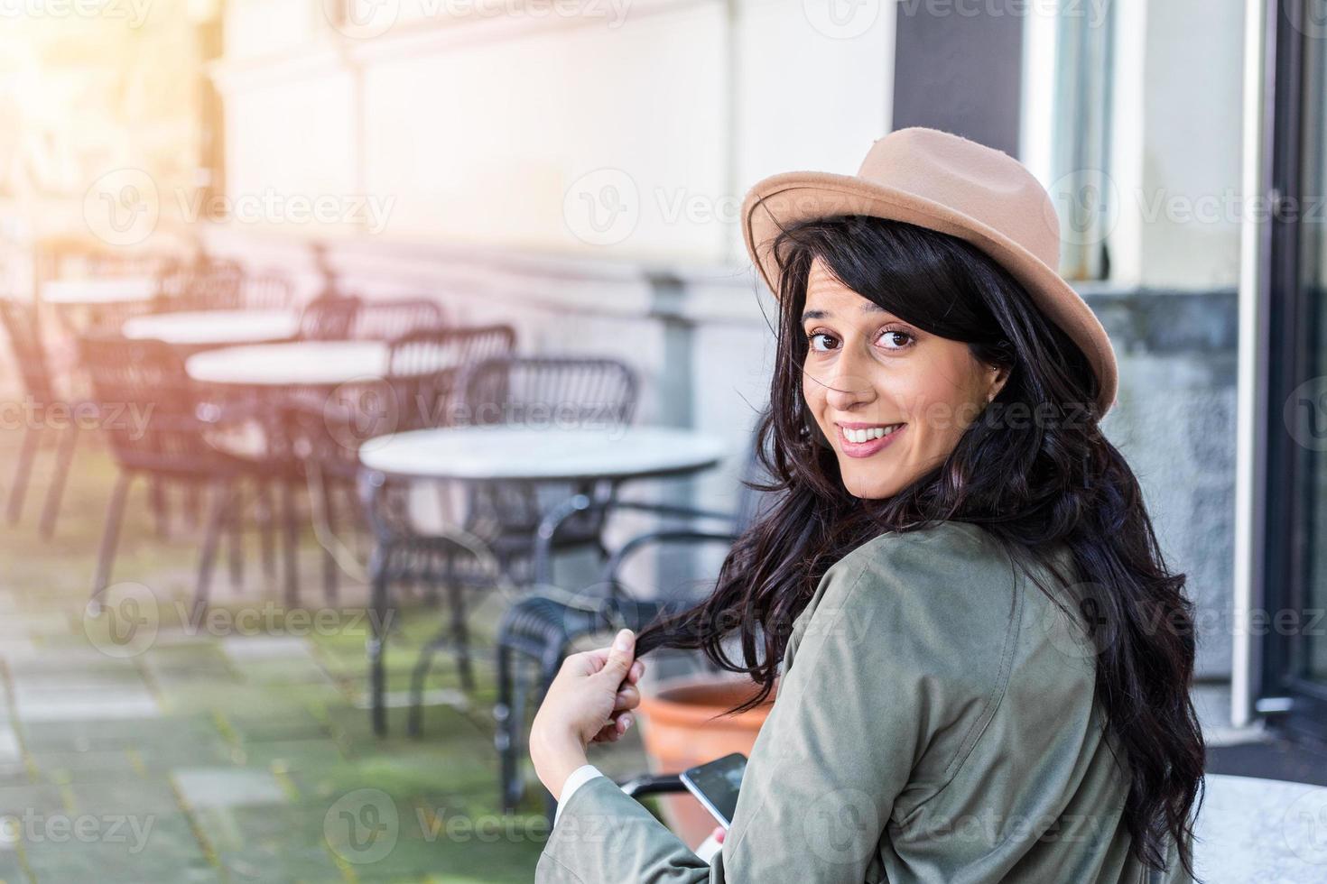 belle jeune femme assise à la cafétéria. heureux étudiant universitaire buvant du café, souriant photo