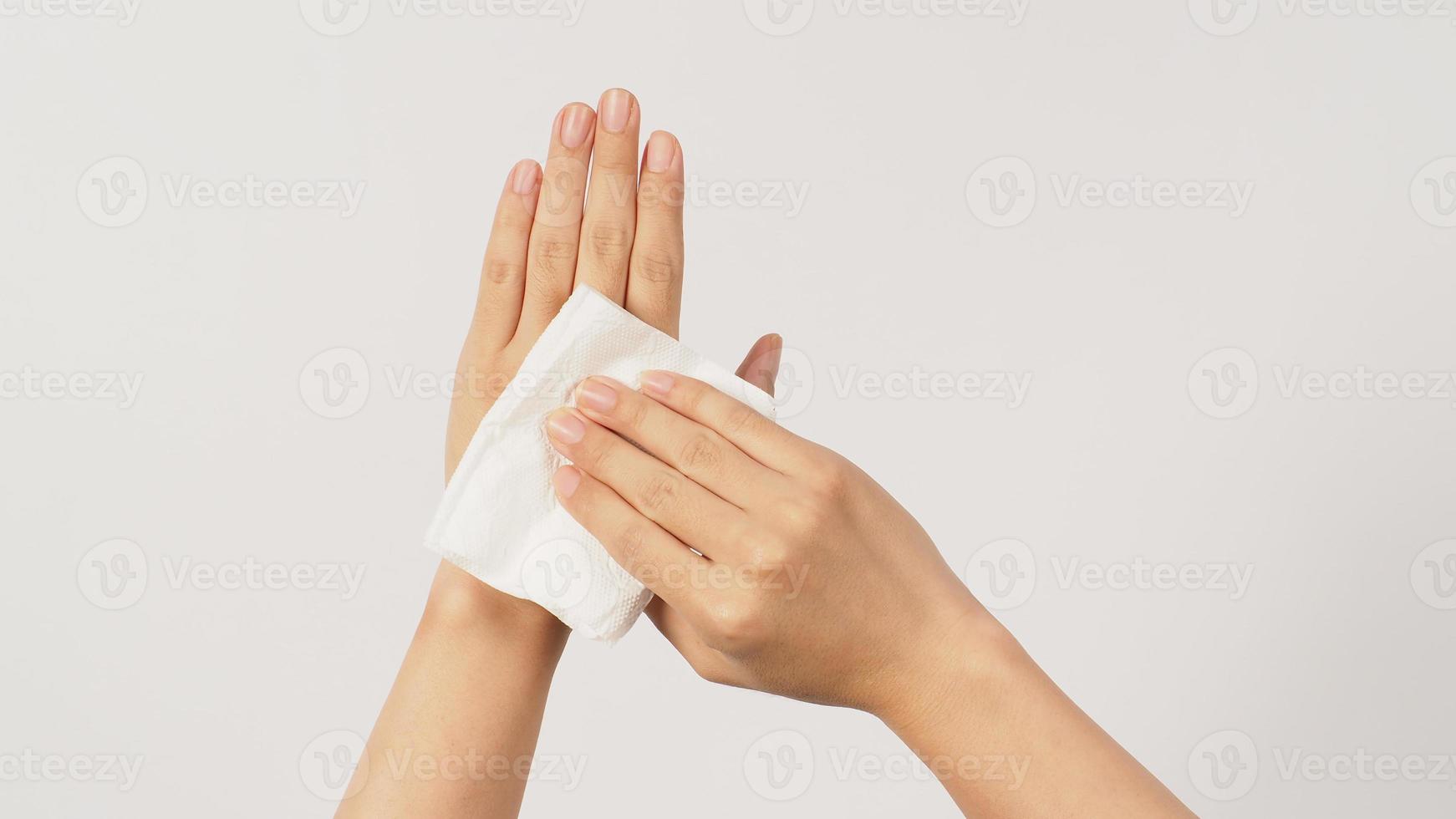 la main tient du papier de soie et des lingettes sur fond blanc. photo