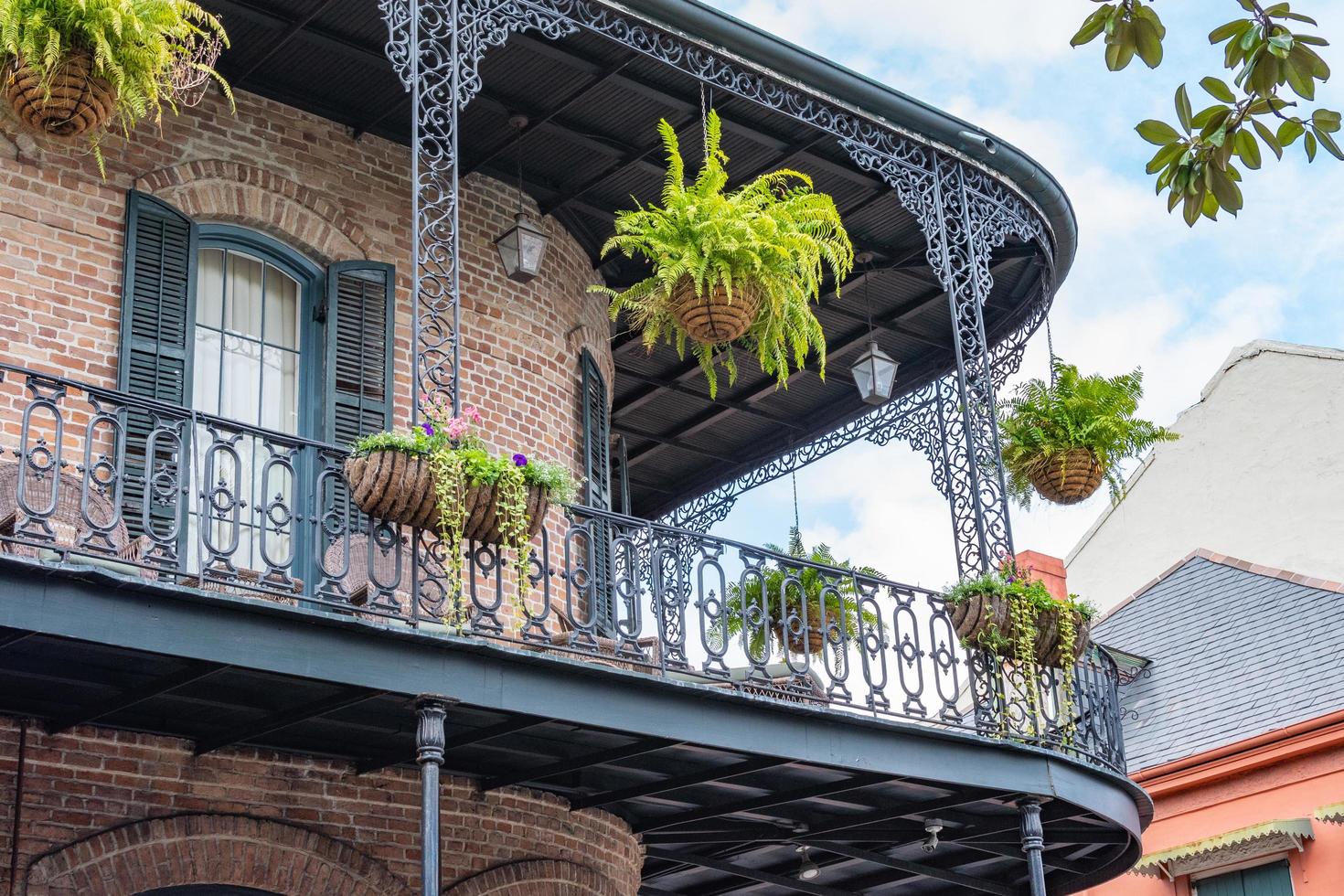 Nouvelle-Orléans, Louisiane, États-Unis. 4 novembre 2022. un beau bâtiment en brique avec un coin arrondi, un balcon en ferronnerie et des plantes suspendues. photo