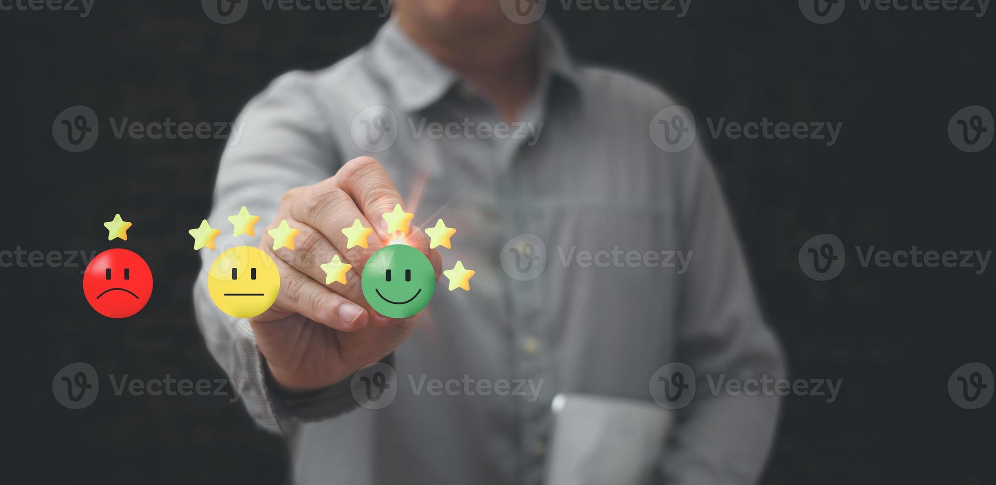 un homme d'affaires tenant un stylo touchant l'écran virtuel sur l'icône du visage souriant heureux pour donner satisfaction dans le service.classement très impressionné.service client et concept de satisfaction photo