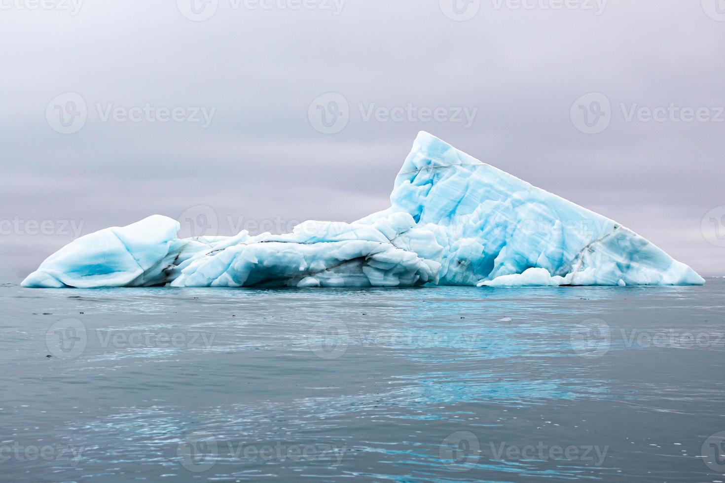 un iceberg bleu flottant dans la mer à svalberg photo