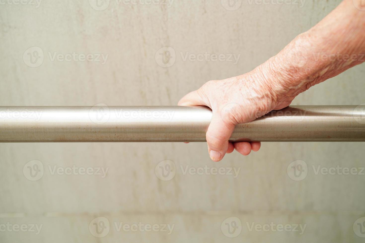 une vieille femme asiatique âgée utilise un rail de support de toilette dans la salle de bain, une barre d'appui de sécurité pour main courante, la sécurité dans l'hôpital de soins infirmiers. photo