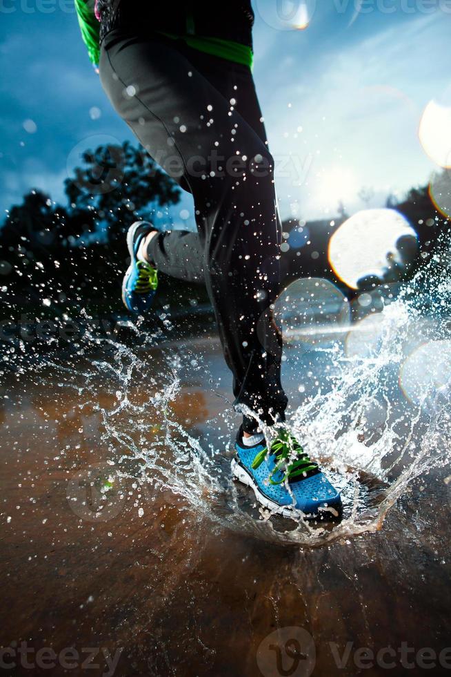 une personne qui court avec des chaussures bleues sous la pluie photo