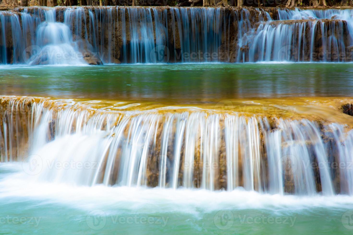 incroyable cascade colorée dans la forêt du parc national au printemps, belle forêt profonde en thaïlande, longue exposition technique, pendant les vacances et les moments de détente. photo