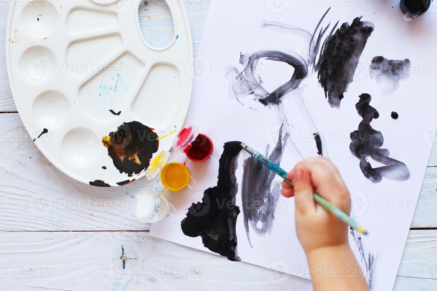 vue d'en-haut. l'enfant dessine un pinceau et peint la vue de dessus. outils d'art à plat pour la peinture. photo