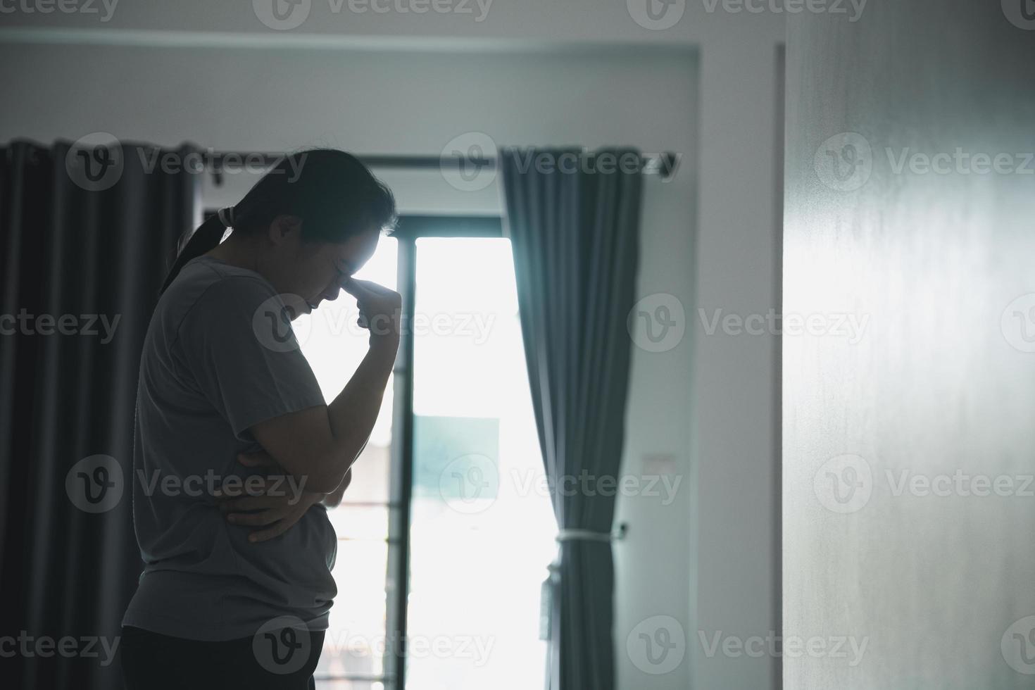schizophrénie avec concept de dépression solitaire et triste en santé mentale. femme déprimée debout contre une pièce sombre se sentant misérable à la maison. les femmes sont déprimées, craintives et malheureuses. photo
