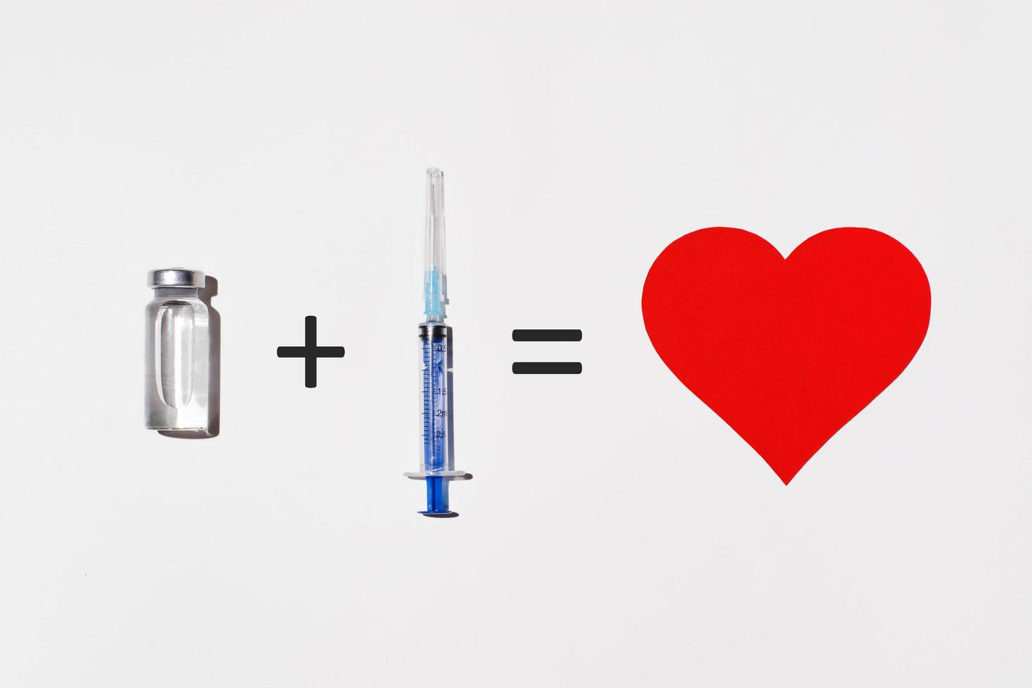concept créatif des avantages pour la santé de la vaccination. flacon de vaccin, seringue et coeur sur fond blanc, plat. exemple mathématique illustrant l'innocuité d'un vaccin photo