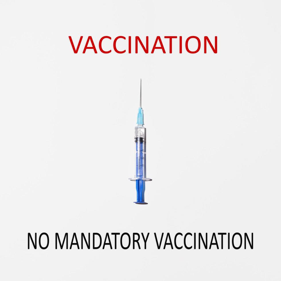 seringue pointant vers le texte rouge vaccination. concept de choix entre la vaccination et la vaccination non obligatoire photo