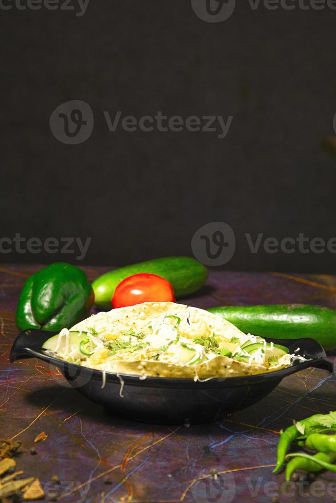 la nourriture indienne connue sous le nom de masala papad a servi de nourriture de départ, la garniture comprend l'oignon, la tomate, les piments verts, la coriandre fraîche, etc. photo