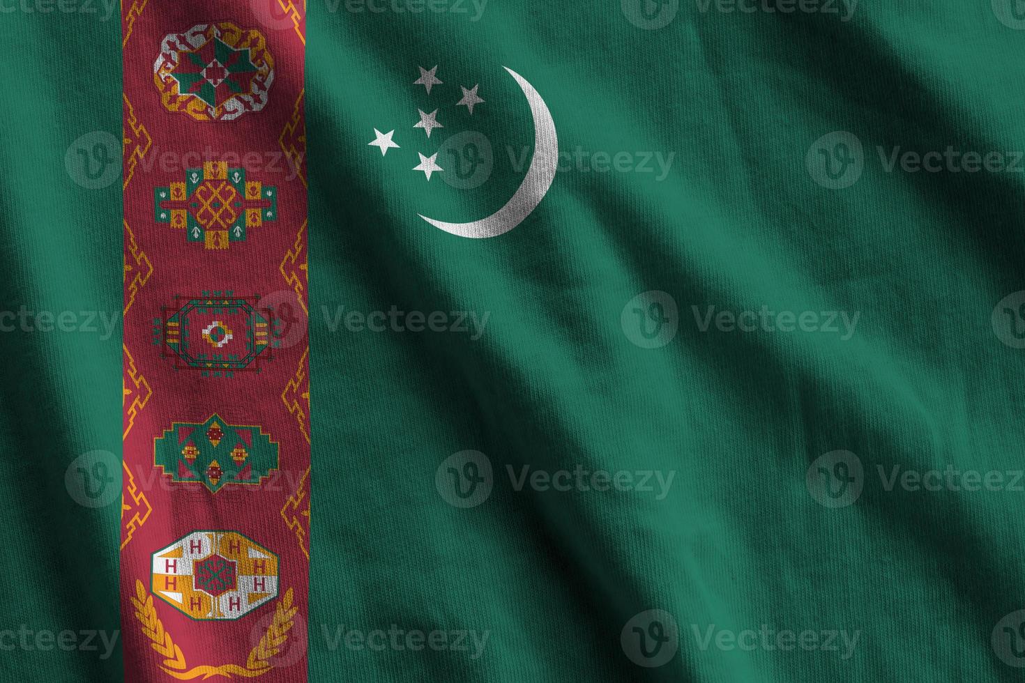 drapeau du turkménistan avec de grands plis agitant de près sous la lumière du studio à l'intérieur. les symboles et couleurs officiels de la bannière photo