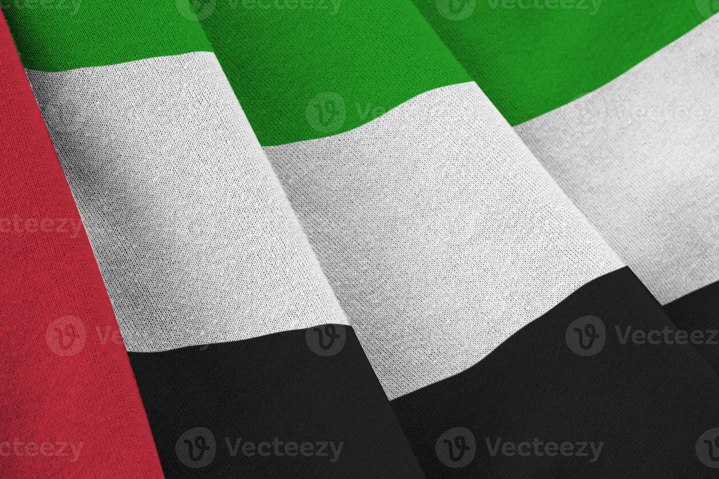 drapeau des émirats arabes unis avec de grands plis agitant de près sous la lumière du studio à l'intérieur. les symboles et couleurs officiels de la bannière photo