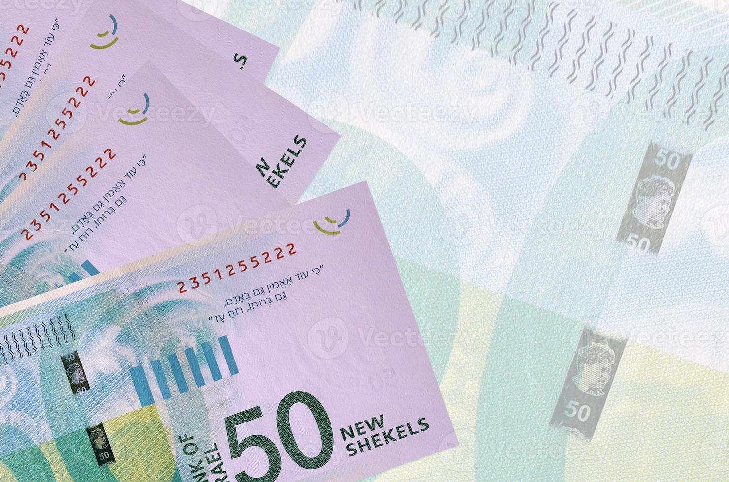 50 billets de nouveaux shekels israéliens sont empilés sur fond de gros billets semi-transparents. arrière-plan abstrait des affaires photo