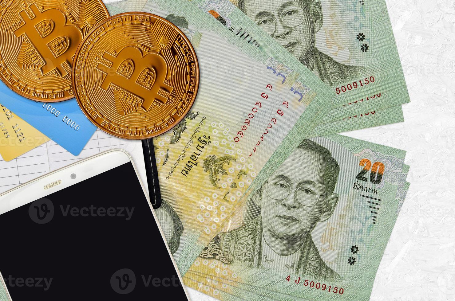 20 billets de baht thaïlandais et bitcoins dorés avec smartphone et cartes de crédit. concept d'investissement en crypto-monnaie. minage ou commerce de crypto photo