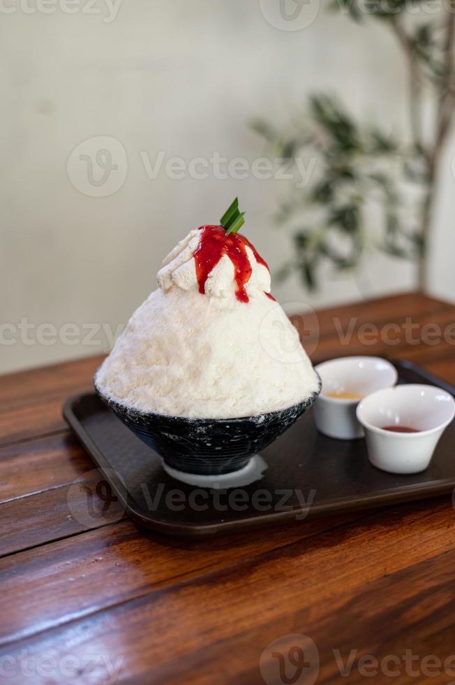 dessert coréen à la glace pilée avec garnitures sucrées, bingsu aux fraises sur table en bois photo