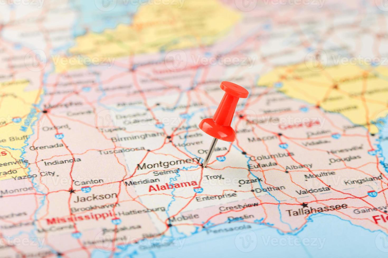 aiguille de bureau rouge sur une carte des états-unis, du sud de l'alabama et de la capitale montgomery. gros plan du sud de l'Alabama avec tack rouge photo