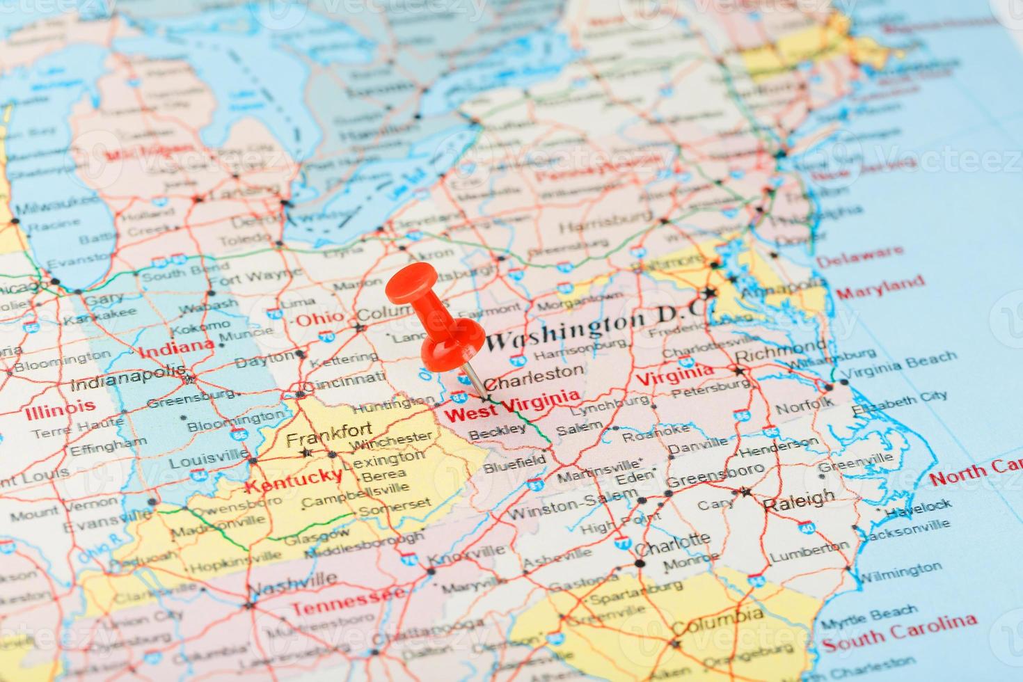 aiguille de bureau rouge sur une carte des états-unis, de la virginie du sud-ouest et de la capitale charleston. gros plan du sud-ouest de la virginie avec tack rouge photo