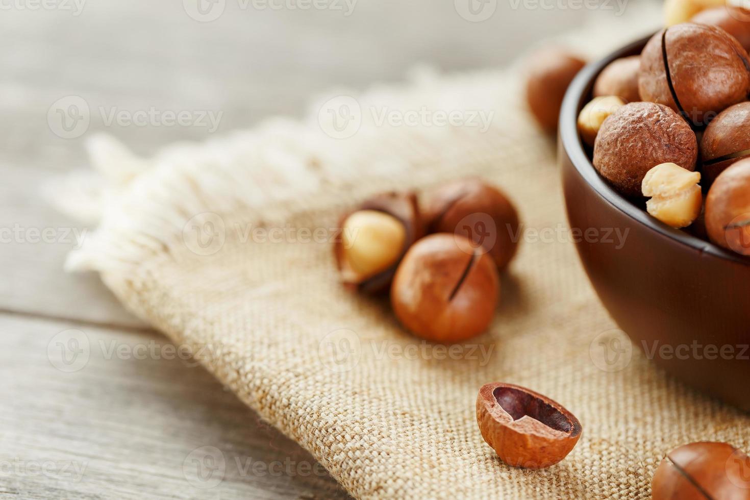 noix de macadamia sur fond de bois avec tissu vintage, concept de superaliments et d'aliments sains photo