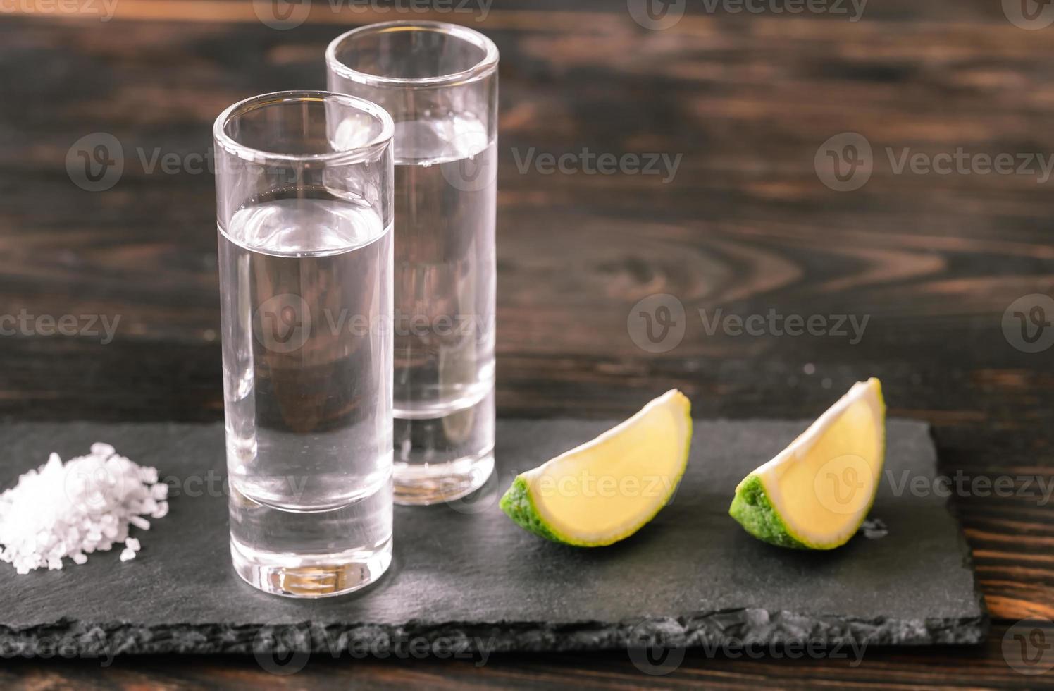 verres de tequila avec des quartiers de citron vert photo