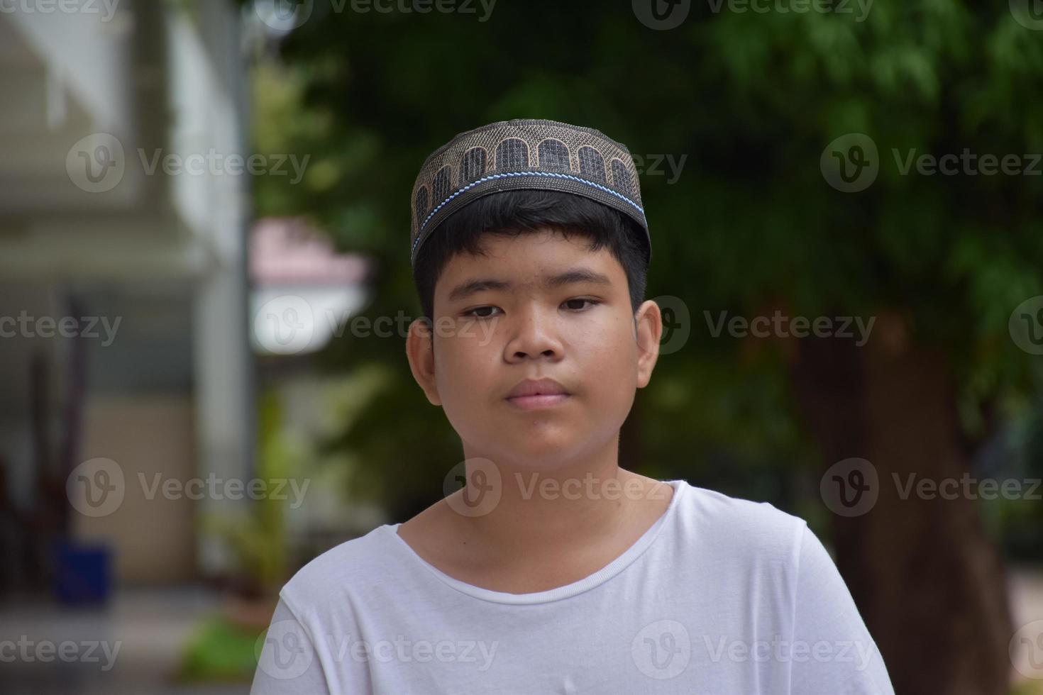 portrait jeune garçon islamique ou musulman d'asie du sud-est en chemise blanche et chapeau, isolé sur blanc, mise au point douce et sélective. photo