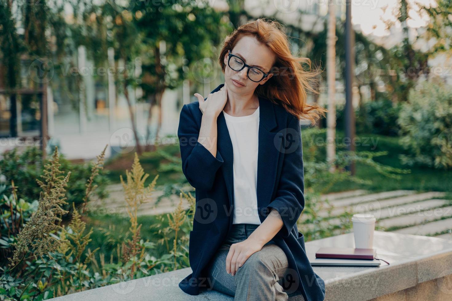 jeune femme fatiguée massant le cou, ressentant des douleurs dans les muscles du corps à cause d'une mauvaise posture au travail photo