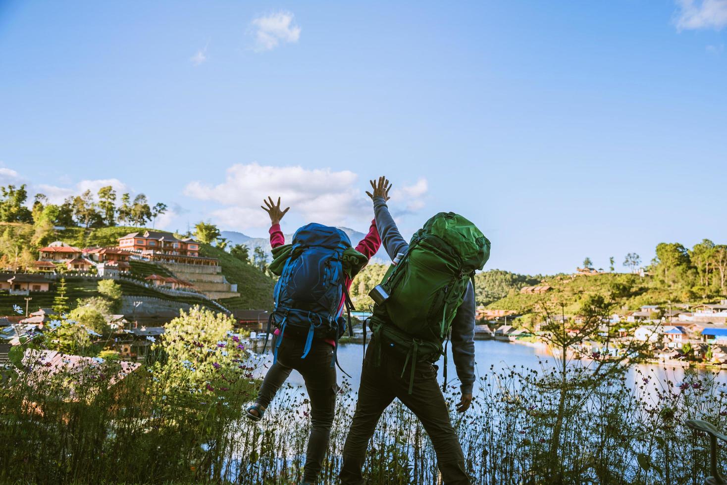 amoureux des femmes et des hommes asiatiques voyagent se détendre pendant les vacances. levez-vous en regardant le paysage sur les montagnes. heureux avec le tourisme de détente. photo