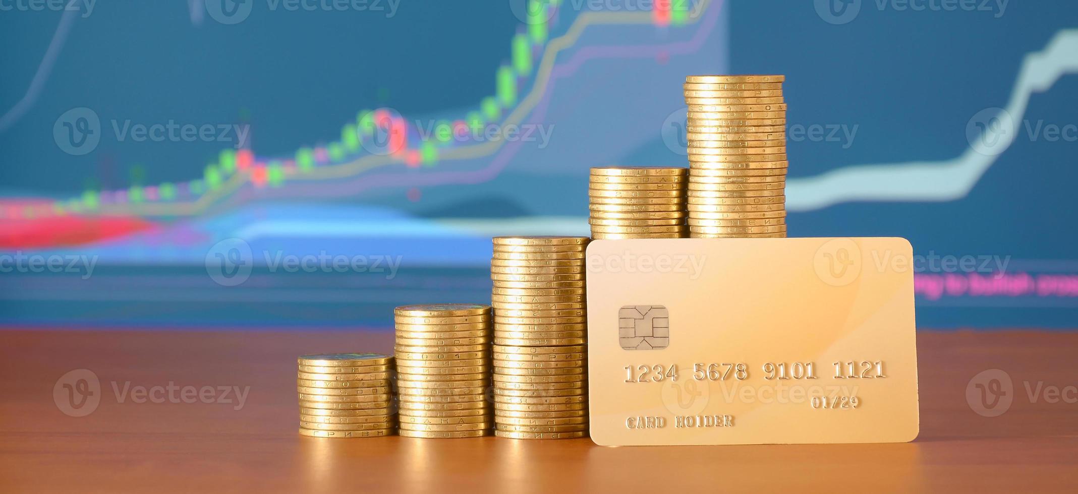 piles de pièces d'or et carte de crédit sur le fond de la courbe de croissance exposée photo