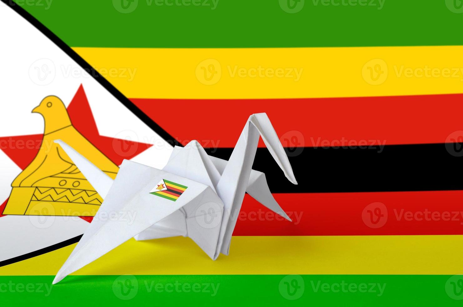 drapeau du zimbabwe représenté sur une aile de grue en papier origami. concept d'art fait à la main photo