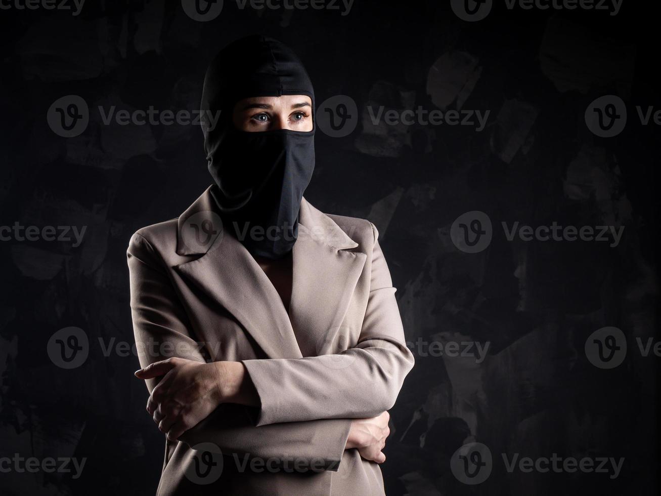 portrait d'une jeune fille dans une cagoule noire et un manteau beige. photo