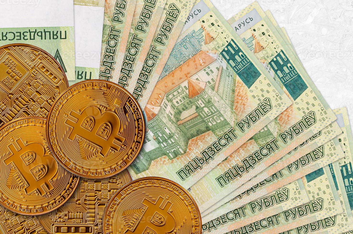 Billets de 50 roubles biélorusses et bitcoins dorés. concept d'investissement en crypto-monnaie. minage ou commerce de crypto photo